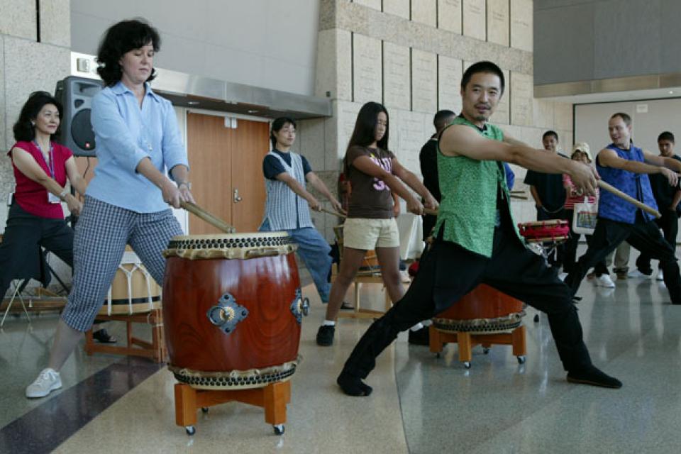 Members from On Ensemble lead an audience in a taiko demonstration